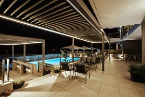 a lounge area with chairs, tables and umbrellas at Andrew's Luxury Residence in Nafplio