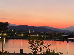 a sunset over a body of water with a city at Yilan Real Fun Homestay in Dongshan