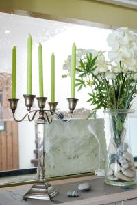 a candle holder and a vase with white flowers at Le Parasol in Ars-en-Ré