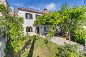 a white house with trees in front of it at House Antonio in Miholascica (66-1) in Miholašćica