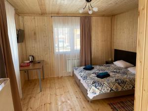 ダホフスカヤにあるDve Reki Holiday Parkのベッドルーム1室(ベッド1台、テーブル、窓付)