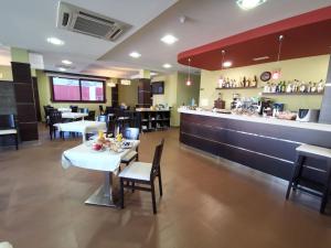 une salle à manger avec des tables et un bar dans un restaurant dans l'établissement Hotel A Bota, à Portonovo