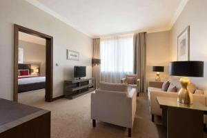 a large hotel room with a living room at Ramada Downtown Abu Dhabi in Abu Dhabi
