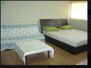 Thung Si Kan的住宿－Room in Guest room - Chan Kim Don Mueang Guest House, located in Pak Kret，一间卧室配有两张床、一张长凳和一张桌子