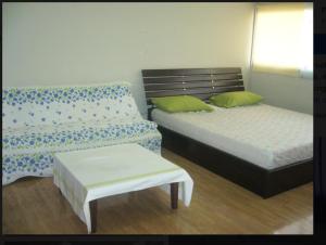 a bedroom with two beds and a bench and a table at Chan Kim Don Mueang Guest House, 550 yards from Impact Muang Thong Thani in Thung Si Kan