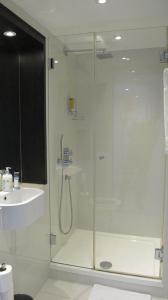 a bathroom with a glass shower and a sink at BLOOMSBURY APARTMENTS in London