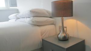 a lamp on a night stand next to a bed at BLOOMSBURY APARTMENTS in London