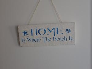 a sign that says home is where the beach is at Vila Cabral 2 Apartments in Sal Rei