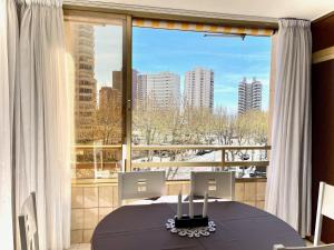 a dining room with a table and a large window at Mariscal 1 - Aloturin Benidorm in Benidorm