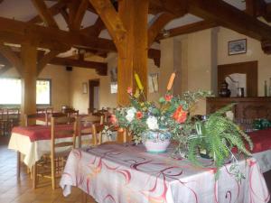 a dining room with a table with flowers on it at Chambres et table d'hôtes - Domaine de Bardenat in Marquay