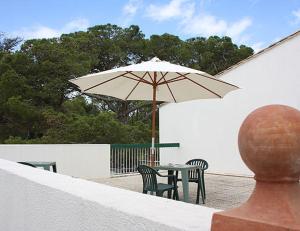 a table and chairs with an umbrella on a patio at Le Parasol in Ars-en-Ré