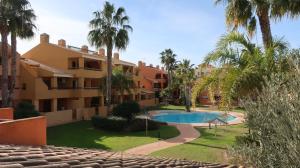 un complejo con piscina y palmeras en Beach Huisje Mar Menor, en Mar de Cristal