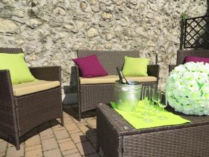 um pátio com cadeiras e uma mesa com copos de vinho em Bella Villa Apartments em Riva del Garda