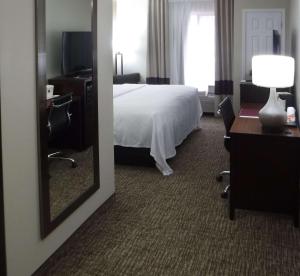 a hotel room with a bed and a mirror at Comfort Inn New River in Oak Hill