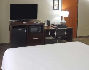 a hotel room with a bed, desk and television at Comfort Inn New River in Oak Hill