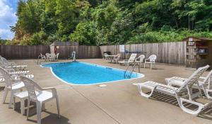 a patio with chairs and a pool and a fence at Comfort Inn New River in Oak Hill