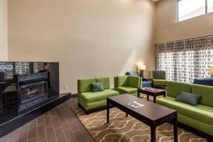 a living room with green couches and a fireplace at Comfort Inn Paducah I-24 in Paducah