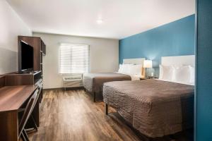 a hotel room with two beds and a flat screen tv at WoodSpring Suites Atlanta Newnan in Newnan +21 photos