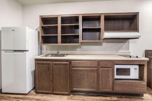 a kitchen with wooden cabinets and a white refrigerator at WoodSpring Suites Atlanta Newnan in Newnan