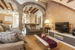 ein Wohnzimmer mit Sofa und Fernseher in der Unterkunft Can Bodeguita in Binissalem