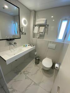 a bathroom with a sink and a toilet and a mirror at City Center Jerusalem in Jerusalem +28 photos