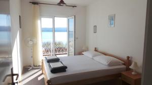 a bedroom with a bed with a view of the ocean at Apartment in Duce with sea view, balcony, air conditioning, WiFi 237-1 in Duće
