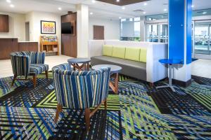 a lobby with a couch and two chairs at Holiday Inn Express & Suites - Fort Myers Airport, an IHG Hotel in Fort Myers