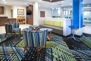 a lobby with a couch and two chairs at Holiday Inn Express & Suites - Fort Myers Airport by IHG in Fort Myers