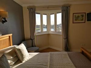 a bedroom with a bed and a window at The River Haven Hotel in Rye