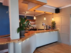 a kitchen with a bar with lights on it at The River Haven Hotel in Rye +36 photos
