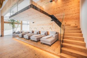 a living room with a couch and a staircase at Hotel Gaspingerhof in Gerlos