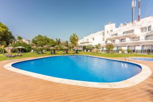 a large swimming pool in front of a building at Carvoeiro Garden Hotel in Carvoeiro