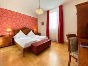 a bedroom with a bed and a red wall at Hotel Rathausglöckel in Baden-Baden