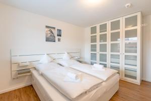 a bedroom with a large bed with white sheets at Alpseeglück in Immenstadt im Allgäu