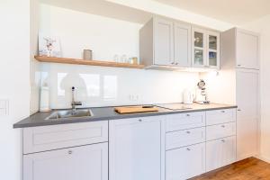 a white kitchen with white cabinets and a sink at Alpseeglück in Immenstadt im Allgäu