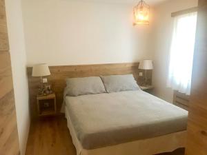 um quarto com uma cama com duas mesas de cabeceira e dois candeeiros em Bilocale nuovo St. Moritz Chesa Arlas em St. Moritz