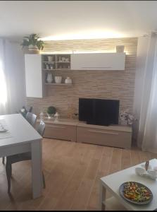 a living room with a flat screen tv on a wall at La Casa Delle Rose 2 in Giba