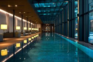 a hotel lobby with a swimming pool and windows at The Chedi Andermatt in Andermatt