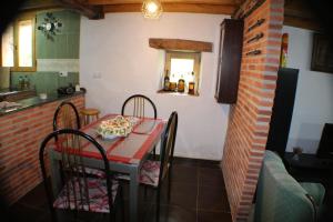 une salle à manger avec une table et des chaises rouges dans l'établissement Vivienda Vacacional Los Picuos - Casas de los Picos, à Robriguero