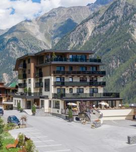 a hotel with mountains in the background at Lakeside by A CASA in Sölden