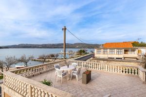 d'une table et de chaises sur un balcon avec vue sur l'eau. dans l'établissement Apartments Edi 581, à Jadrtovac