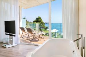 a living room with a tub and a view of the ocean at ME Ibiza - The Leading Hotels of the World in Santa Eularia des Riu