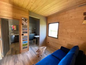 sala de estar con sofá azul y paredes de madera en World Hotel, en Saint-Vulbas