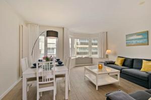 a living room with a couch and a table at Knokke La Douce - Cozy apartment with side sea-view at only 50 meters from beach in Knokke-Heist