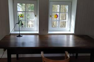 a table with a lamp in front of two windows at Refugium Klosterhaus Nettersheim in Nettersheim