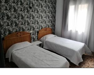 A bed or beds in a room at Alcaravaneras Hostel
