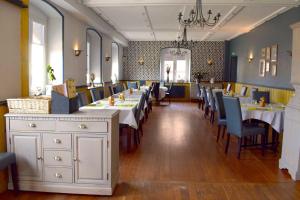 una sala da pranzo con tavoli e sedie in un ristorante di Le rendez-vous des Copains a Logelheim