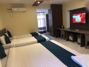 a hotel room with two beds and a television at Sky Loft near Kempegowda International Airport in Muthugadahalli