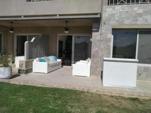 einbay 3 bedrooms garden + pool view في العين السخنة: فناء مع اثنين من الأرائك البيضاء على منزل