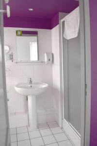 ein weißes Bad mit einem Waschbecken und einer Dusche in der Unterkunft Le rendez-vous des Copains in Logelheim